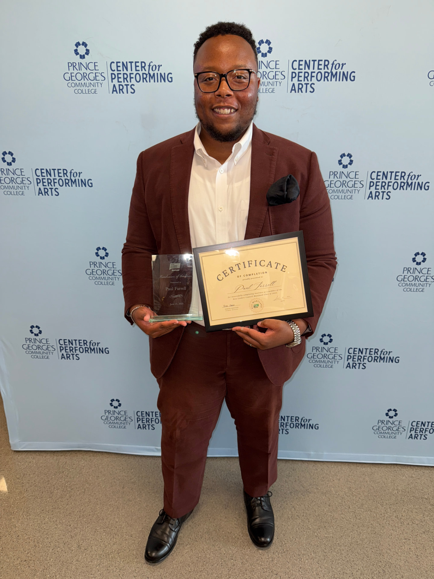 Paul Farrell holding the NLC fellowship award and his New Leaders Council Maryland certificate of completion